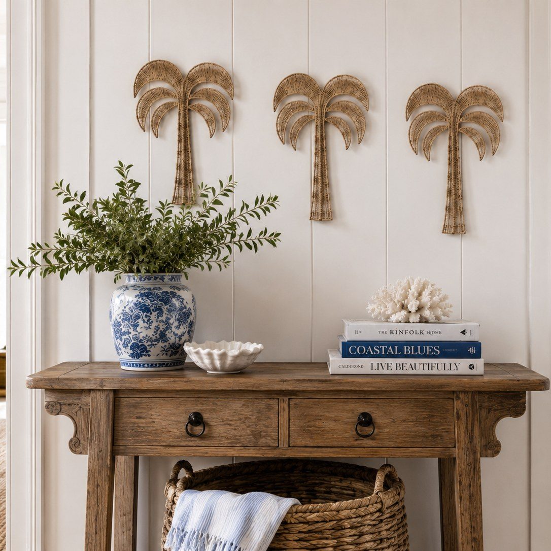 Three woven palm tree wall decor pieces arranged in a row above a wooden entryway console table